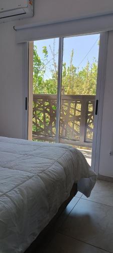 a bedroom with a bed and a large window at Dpto Sarmiento Centro in San Juan