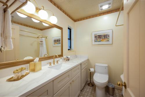 a bathroom with a sink and a toilet and a mirror at Mill Rose Inn in Half Moon Bay