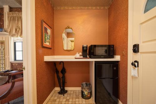 a room with a microwave on a counter next to a door at Mill Rose Inn in Half Moon Bay