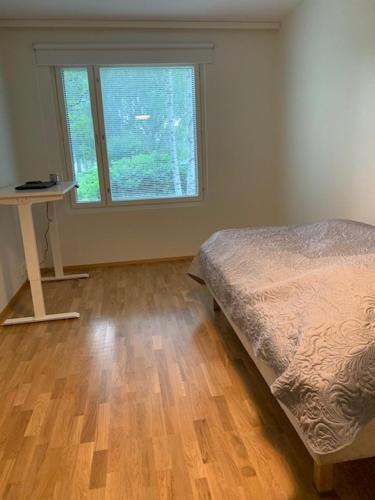 Schlafzimmer mit einem Bett und einem Fenster in der Unterkunft Uusi kolmio in Oulu