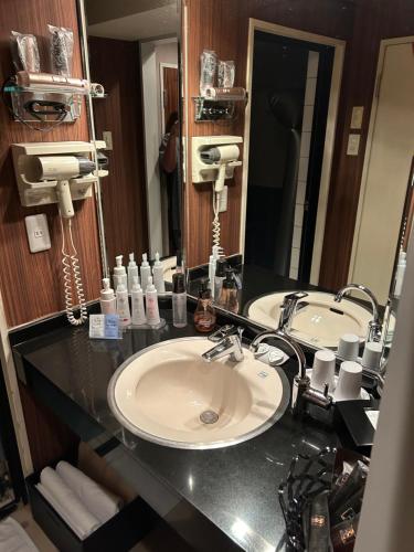 a bathroom with two sinks and a large mirror at Hotel AKAIKUTSU - Adult Only in Yokohama