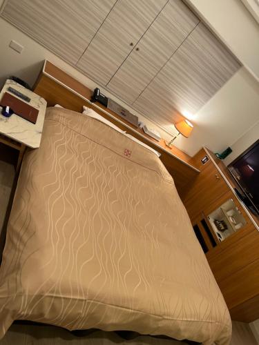 a large bed in a room with a desk at Hotel AKAIKUTSU - Adult Only in Yokohama