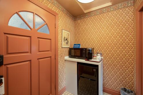 a kitchen with a door and a microwave on a counter at Mill Rose Inn in Half Moon Bay