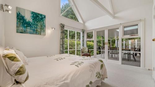1 dormitorio blanco con 1 cama y comedor en Jamieson Cottage, en Wentworth Falls