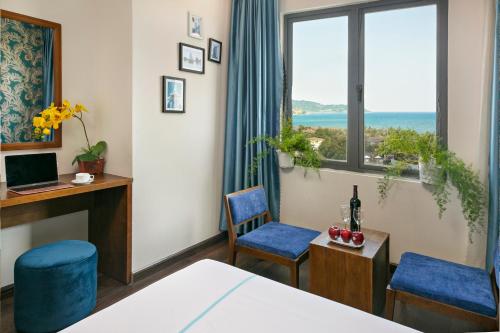 a room with a bed and two chairs and a window at Near Beach Lamore Hotel in Danang