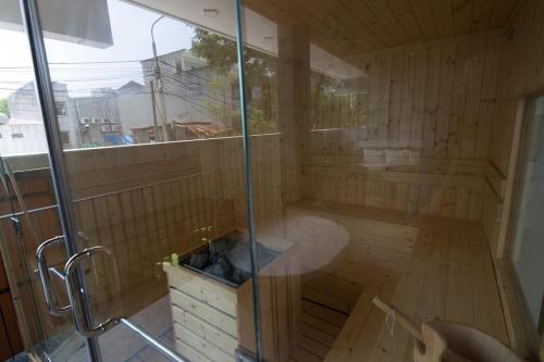 una sauna con ducha y puerta de cristal en My Khe Beach Villa, en Da Nang