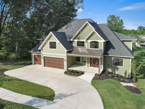 a house with a garage and a driveway at Luxurious Mansion, Deck, Patio, Chef’s Kitchen in Crown Point