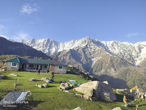 マクロード・ガンジにあるHOTEL HIMALYAN PARADISEの山を背景にした畑の家