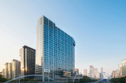 een hoog gebouw met glazen ramen in een stad bij Renaissance Beijing Capital Hotel in Beijing
