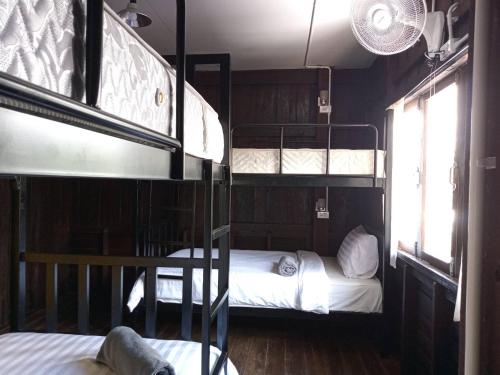 a room with two bunk beds and two windows at Imchai in Pai