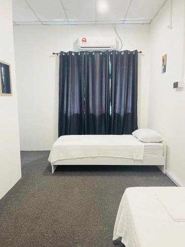 Cette chambre comprend 2 lits et un rideau. dans l'établissement AK Greenrise Meru, à Ipoh