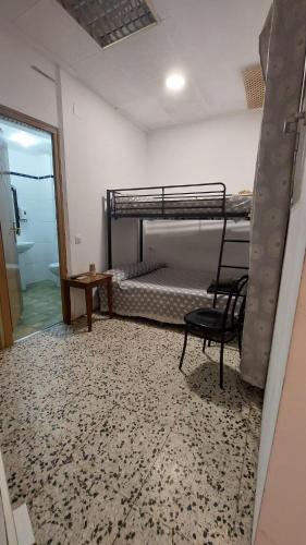 a room with two bunk beds and a chair at Pension Suiza in Reus