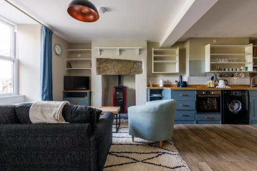 a living room with a couch and a kitchen at Cosy, 2-bedroom Snowdonia cottage mountain retreat in Tanygrisiau