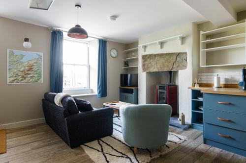 a living room with a couch and a chair and a desk at Cosy, 2-bedroom Snowdonia cottage mountain retreat in Tanygrisiau
