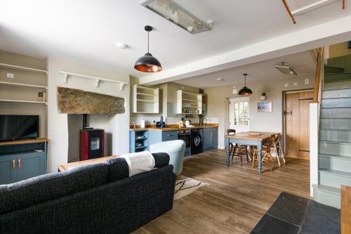 a living room and kitchen with a couch and a table at Cosy, 2-bedroom Snowdonia cottage mountain retreat in Tanygrisiau