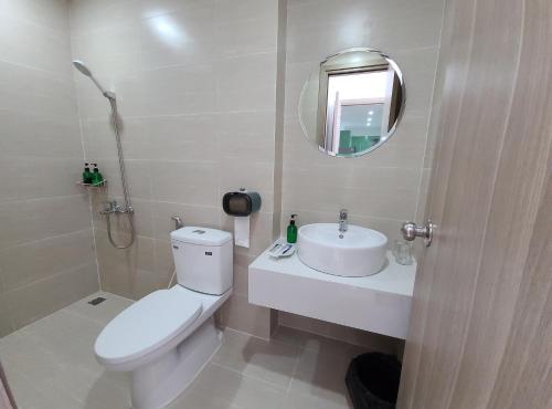 a bathroom with a toilet and a sink and a mirror at Ina apartment - Nera garden Hue in Hue