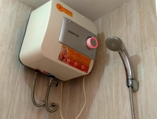 um dispensador de sabão na casa de banho com chuveiro em Apartemen Malioboro city by Ameliarooms em Yogyakarta