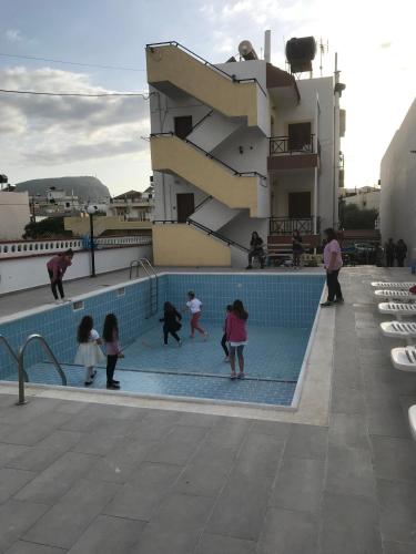 a group of children playing in a swimming pool at Eleni Apartments in Hersonissos