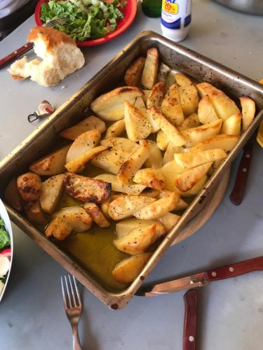 a pan filled with potatoes on a table at Eleni Apartments in Hersonissos