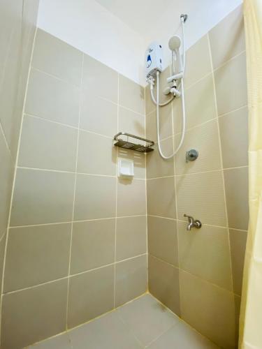 a shower in a bathroom with a shower head at Luxury Two Bedroom with Balcony in SOUTH RESIDENCE of Las Pinas in Manila