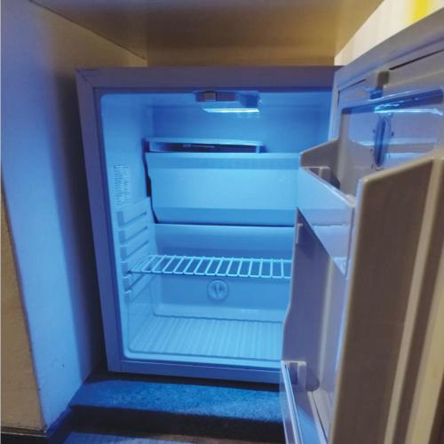 pusta lodówka z otwartymi drzwiami w pokoju w obiekcie Room in Genting Highland w mieście Genting Highlands