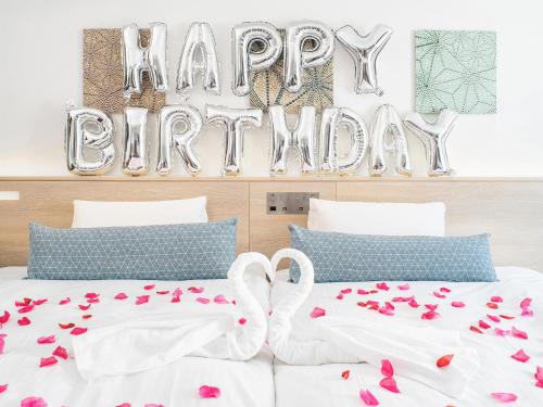 two beds with a happy birthday sign in a bedroom at Vessel Inn Sakae Station in Nagoya