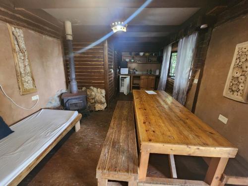 a large wooden table in a room with a stove at Biktot Ba Arafel in Nimrod
