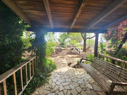 a wooden pergola with a bench and a table at Biktot Ba Arafel in Nimrod