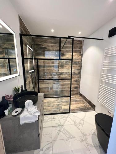 a bathroom with a black tub and a sink at Le Clos fleuri in Fauvillers