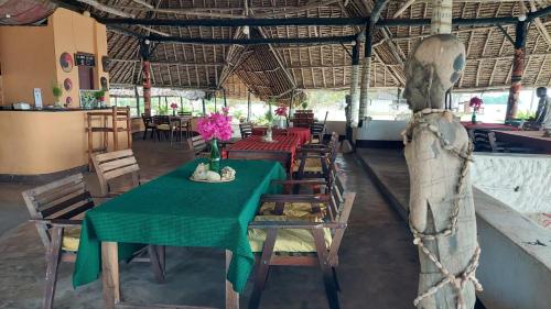 uma sala de jantar com uma mesa verde e cadeiras em Funky Squids Beach Resort em Bagamoyo