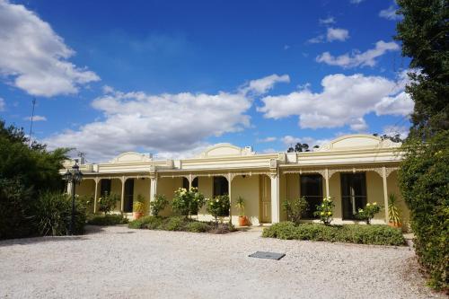 a large yellow house with a yard at Acacia Terraces in Echuca