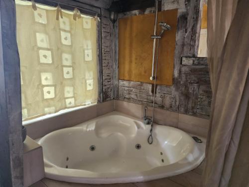 a bath tub in a bathroom with a window at Biktot Ba Arafel in Nimrod
