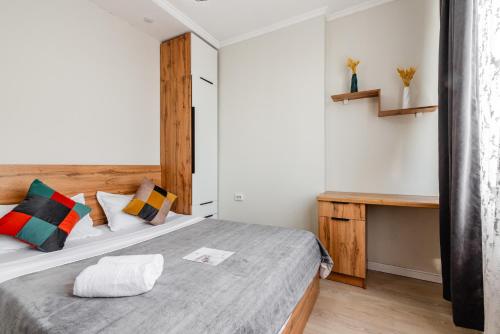 - une chambre avec un lit et un bureau en bois dans l'établissement Очаровательная квартира в ЖК Атлант, à Almaty