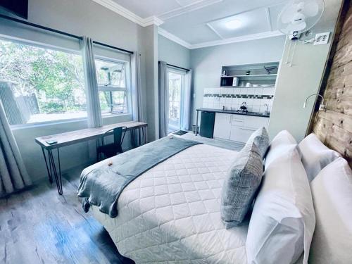 Schlafzimmer mit einem Bett, einem Schreibtisch und einem Fenster in der Unterkunft Madeira Bed in Queenstown