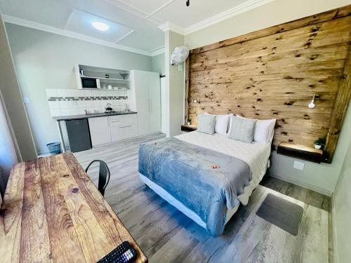 a bedroom with a bed and a wooden wall at Madeira Bed in Queenstown