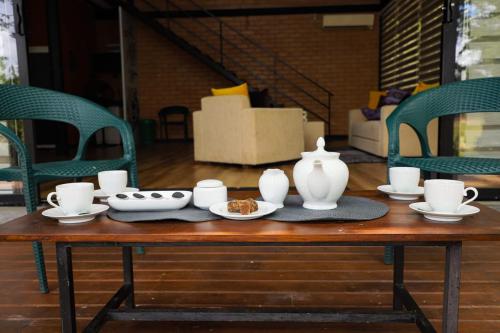 a wooden table with a vase and dishes on it at Life of Leisure Wilpattu in Pahala Maragahawewa