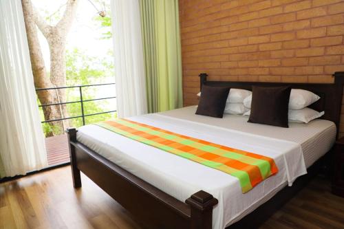 a bed in a room with a balcony with a window at Life of Leisure Wilpattu in Pahala Maragahawewa
