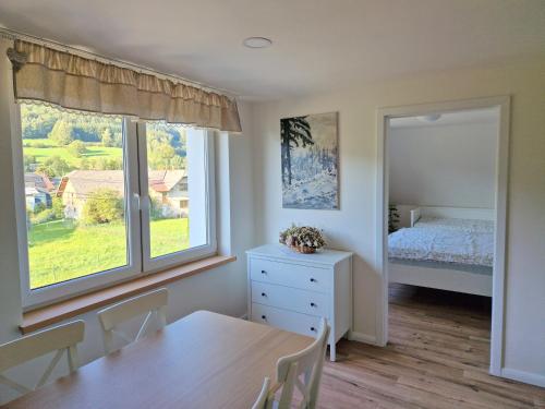 1 dormitorio con mesa, cama y ventana en Apartmány Lipovka, en Lipová-lázně