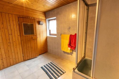a bathroom with a shower and a yellow towel at Ferienwohnung Weitblick mit Sauna in Daisendorf