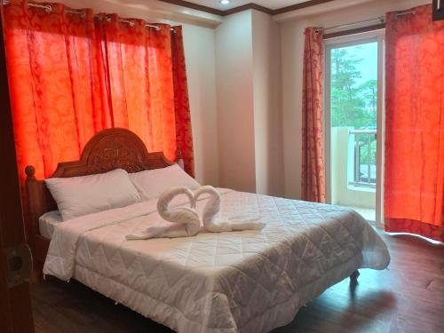 a bedroom with a bed with two hearts on it at havens comfy apartments at Bonbel Condominium in Baguio
