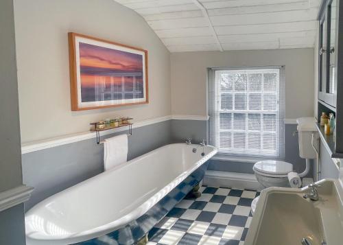 a bathroom with a white tub and a toilet at Haveringland Hall in Cawston