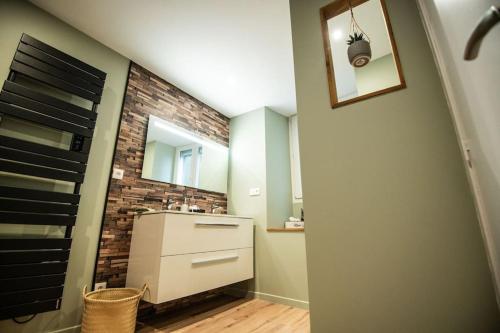 a bathroom with a sink and a brick wall at La Sublime Love House in Briey