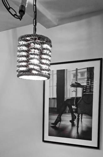 a chandelier and a picture of a woman in a chair at La Sublime Love House in Briey