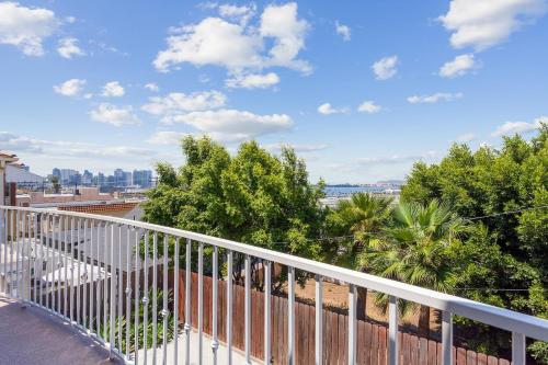 a balcony with a white railing and trees at Charming Retreat on West Quince Street condo in San Diego