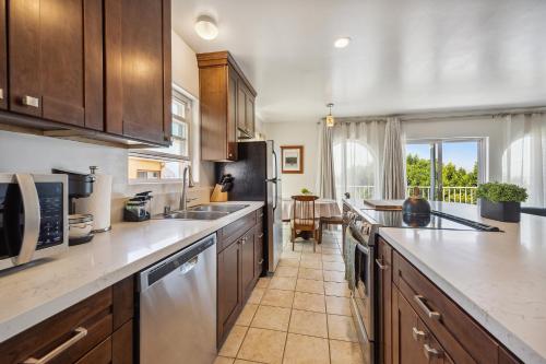 a kitchen with wooden cabinets and stainless steel appliances at Charming Retreat on West Quince Street condo in San Diego