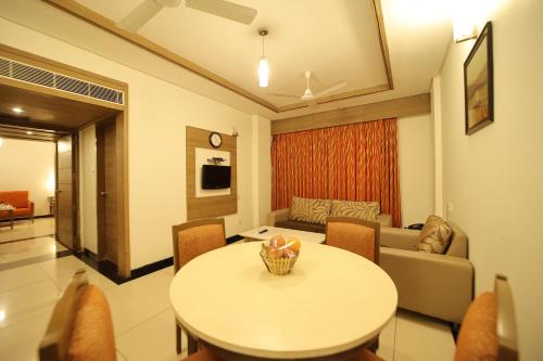 a living room with a table and a couch at Clinton Park Inn in Velānganni