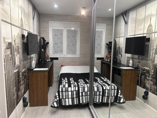 1 dormitorio con 1 cama y TV en Habitación New York - 5 Torres, en Madrid