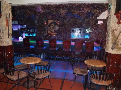 eine Bar mit Stühlen und Tischen in einem Zimmer in der Unterkunft Hotel Olivia in Nogales
