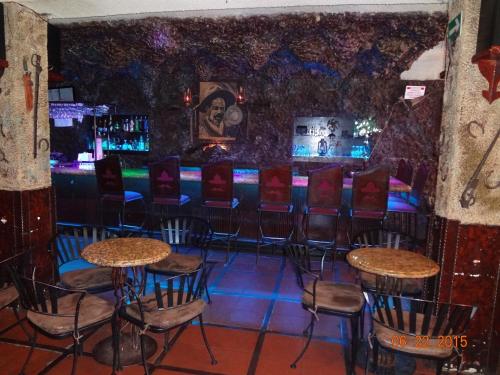 eine Bar mit Stühlen und Tischen in einem Raum in der Unterkunft Hotel Olivia in Nogales