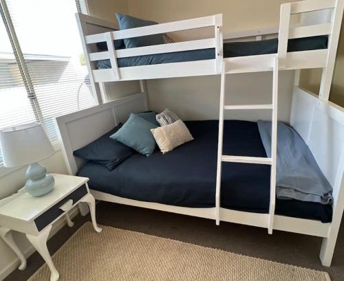 ein Schlafzimmer mit einem Etagenbett mit einem Schreibtisch und einem 6-dx-dx-Bett in der Unterkunft Copper Shores Holiday House in Wallaroo